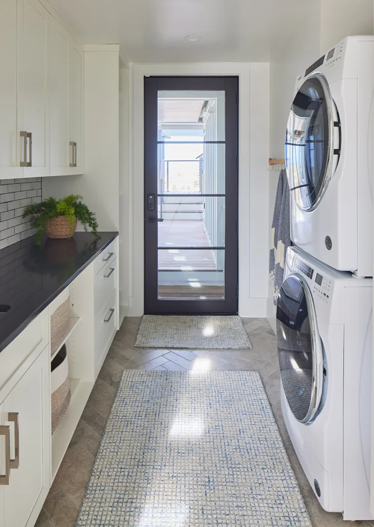 Laundry room with custom cabinets and a stacked washer/dryer